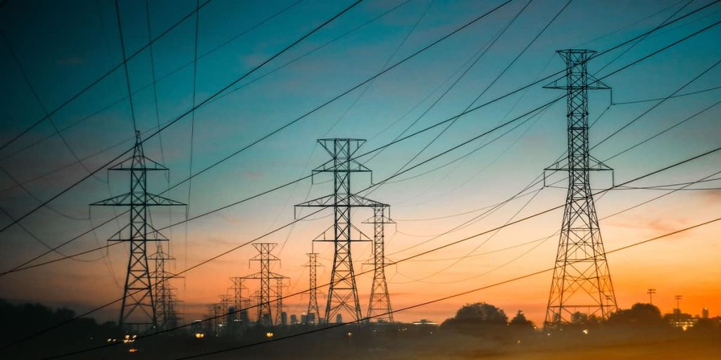 Energy power lines against an orange and yellow sunset